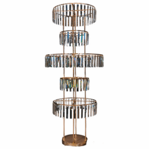 A tall centerpiece with five tiers of varying diameters, each of which have reflective rectangles hanging from them