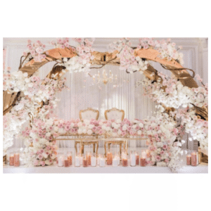 A large archway in the style of tree branches with many flowers arranged around it